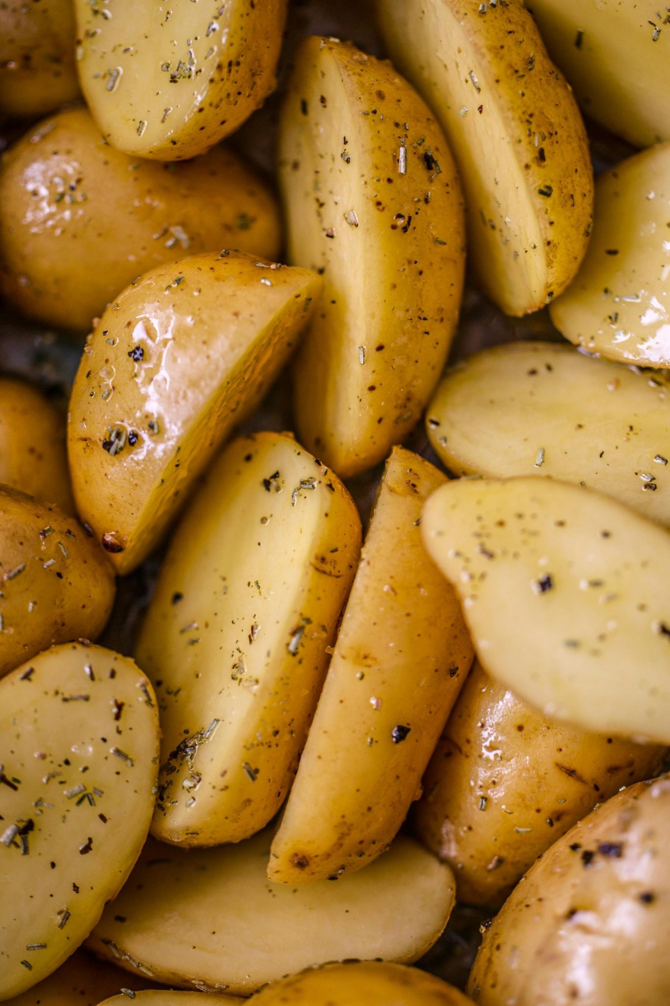 Auksinės spalvos keptos bulvės apšlakstytos tyru alyvuogių aliejumi.